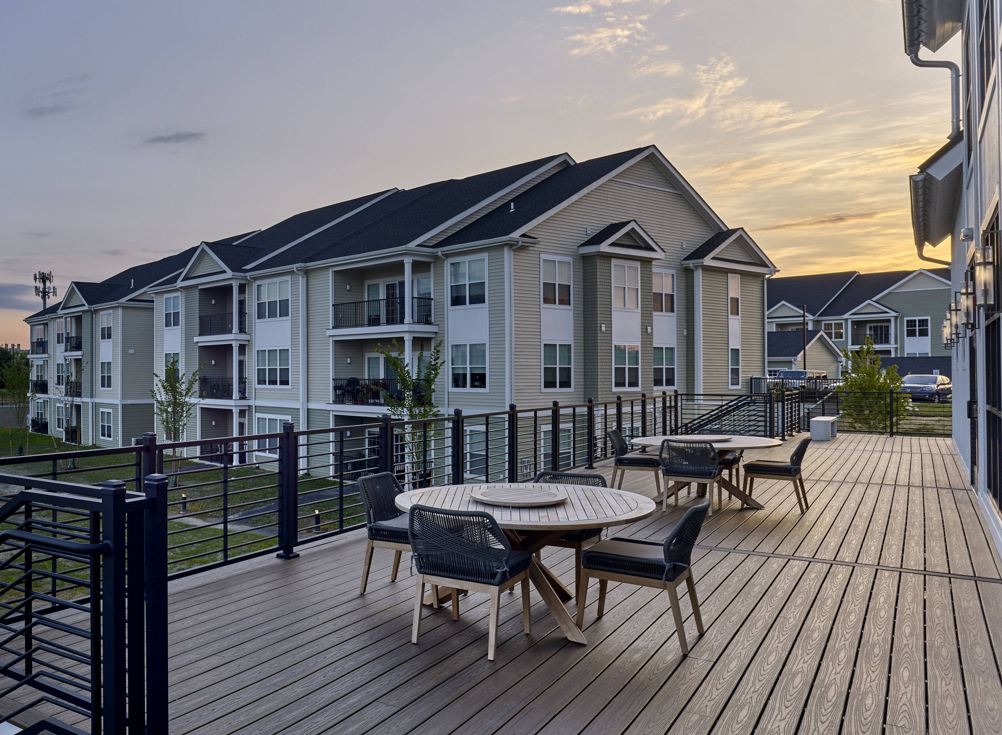 an apartment building with a patio with a table and chairs on it